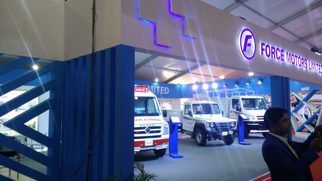 Force Motors exhibition stand vehicle lineup with backlit branding